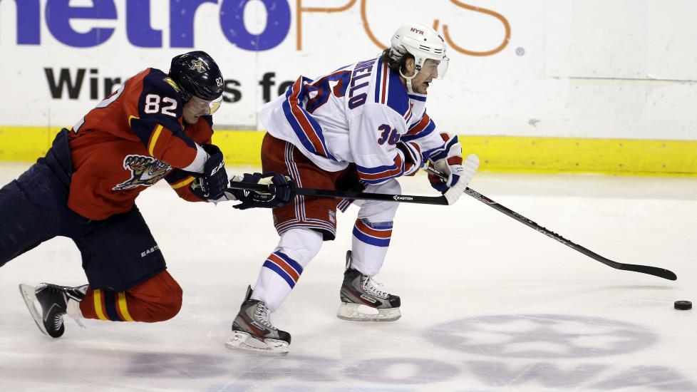 KLARE FOR SLUTTSPILL: Mats Zuccarello Aasen og hans New York Rangers ble i natt klare for NHL-sluttspillet etter 4-3-seier over Carolina Hurricanes. Her er nordmannen i duell mot Florida Panthers' Peter Mueller tidligere i uka. Foto: AP Photo / J Pat Carter / NTB Scanpix