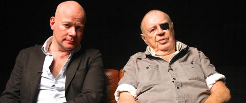 �To middelaldrende menn diskuterer mannsrollens krise foran en taus, naken kvinne.�