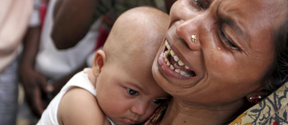 H�Y PRIS: En mor og hennes datter frykter d�rlig nytt om slektninger og venner som jobbet med � lage kl�r p� Rana Plaza. N� raser folket etter ulykken. Foto: A.M.Ahad / AP / Scanpix.