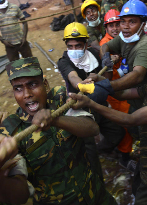 REDNINGSARBEIDERE: Folk fors�ker � flytte store betongblokker vekk for � redde mulige overlevende fra � sitte fanget under ruinene av den kollapsede bygningen. Foto: Ismail Ferdous/AP
