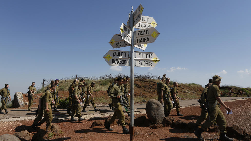 N�R FIENDELAND:  Israelske soldater g�r forbi skiltet som viser avstanden mellom Golanh�yden, der de er, og steder de er uvelkomne, som Bagdad og Damaskus. FNs generalsekret�r Ban Ki-moon uttrykte i g�r sin bekymring over Israels angrep inne i Syria, men sa samtidig at FN ikke kunne bekrefte eller avkrefte om angrepene faktisk hadde funnet sted. Foto: Baz Ratner / Reuters / Scanpix