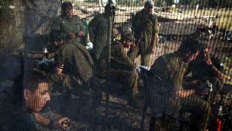 P� VENT:  Israelske soldater spiser i dag lunsj og venter n�r de utplasserte stridsvognene p� den israelsk-okkuperte Golanh�yden, som ligger like ved Syrias grense. De neste dagene og ukene vil vise om Israel har flyttet den r�de linja i en mer offensiv og farligere retning. Foto: Menahem Kahana/Afp/Scanpix