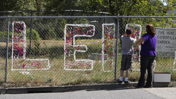 MINNES LEILA: En l�rer hjelper en elev med � henge opp b�nd til minne om drepte Leila Fowler (8). Foto: Rich Pedroncelli / AP Photo
