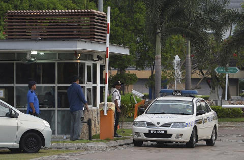 <b>RANSAKET PILOTENS BOLIG:</b> Her kjører en politibil ut fra en vaktpost foran den savnede Malaysia Airlines-pilotens bolig i Shah Alam, like utenfor Kuala Lumpur i Malaysia. Politiet skal ha tatt med seg flere poser med eiendeler, ifølge journalister på stedet. 