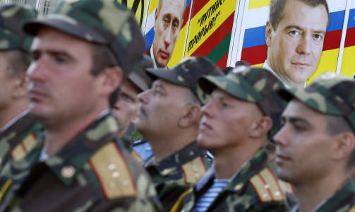SER TIL RUSSLAND: Soldatene gikk i parade med bannere som viste bilde av Russlands president og statsminister. Fortsatt holder den 14. russiske armeen hus her, 18 �r etter at Sovjetunionen gikk i oppl�sning.
De har lovet � trekke seg ut av Transnistria mange ganger. Foto: REUTERS/Gleb Garanich
