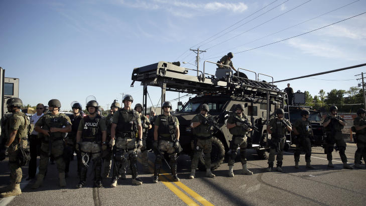 TUNGT BEVÆPNET: Tungt bevæpnet politi gjorde seg klare for en fjerde kveld med store demonstrasjoner i Ferguson i Missouri etter at ubevæpnede Michael Brown (18) ble skutt og drept av politiet lørdag. Foto: AP Photo/Jeff Roberson TUNGT BEVÆPNET: Tungt bevæpnet politi gjorde seg klare for en fjerde kveld med store demonstrasjoner i Ferguson i Missouri etter at ubevæpnede Michael Brown (18) ble skutt og drept av politiet lørdag. Foto: AP Photo/Jeff Roberson