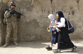 BETONG-HVERDAG: To skolejenter g�r forbi en amerikansk soldat i Ameen-distriktet i Bagdad. Foto: Thaier al-Sudani, Reuters.