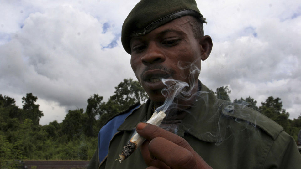 R�YKER MARIHUANA: En soldat fra Kongos regjeringsh�r r�yker marihuana ved frontlinjen i Kibati, �st i landet. Flere andre soldater er ogs� ruset, blant annet p� alkohol. FOTO: REUTERS/Emmanuel Braun/SCANPIX