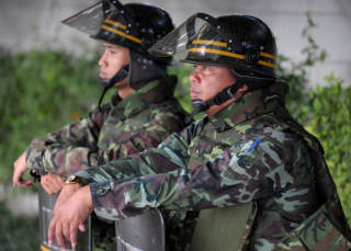 AVVENTENDE: Sikkerhetsstyrker vokter regjeringsbygget i Bangkok. Foto: AFP PHOTO/Pornchai KITTIWONGSAKUL/SCANPIX