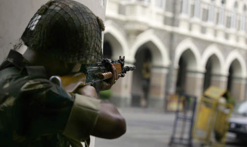 DRAMA I FLERE DAGER: En indisk soldat sikter mot Taj Mahal Hotel der flere gjester ble holdt som gisler av Mumbai-terroristene.  FOTO: AP Photo/Altaf Qadri/SCANPIX