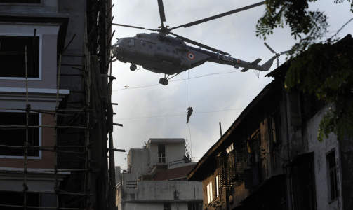 REDNINGSAKSJON: En indisk kommandosoldat rappellerer ned fra et helikopter for � gjenopprette kontroll p� det j�diske Nariman House. Foto: Pedro Ugarte/AFP/Scanpix