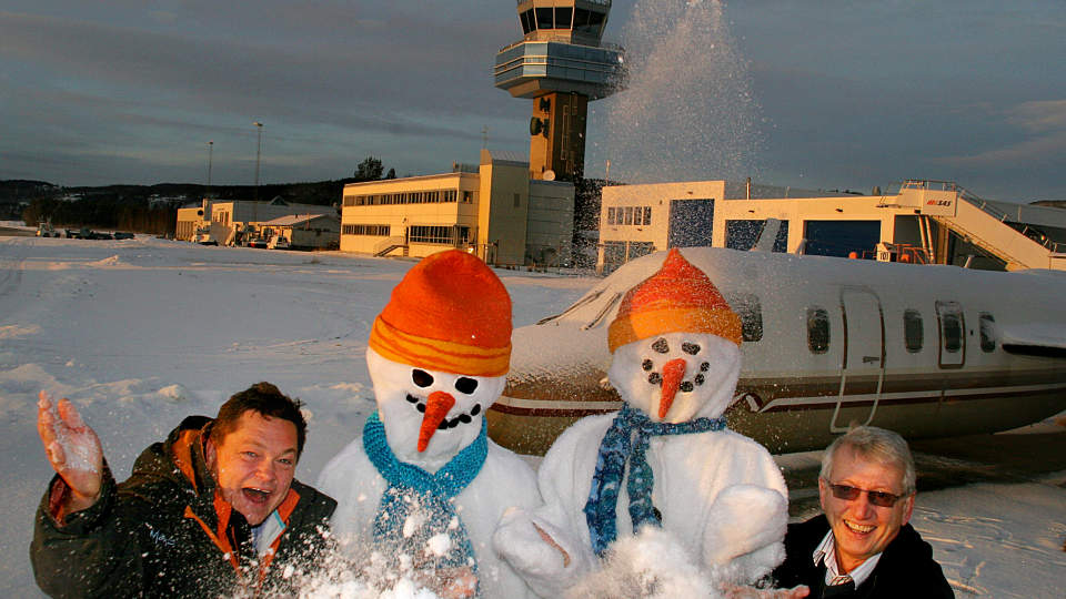 SN�GLEDE: Even Hegbom, sn�mennene og Martin N. Berntzen inviterer turistene til Snowman international Airport. (Ps. Flyet i bakgrunnen har tilh�rt John Travolta, men er n� et treningsfly for flymekanikere.Foto: Odd Roar Lange