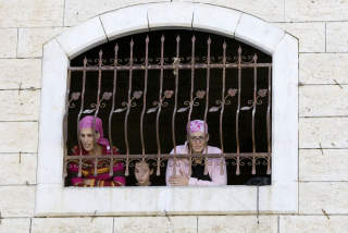 NEKTER � FORLATE OKKUPERTE HUS: J�diske settlere ser ut p� andre settlere som sl�ss med israelsk grensepoliti i n�rheten av det okkuperte stridshuset i Hebron i g�r. Foto: AFP/Scanpix