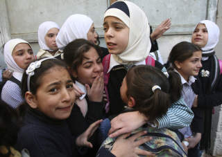 VANSKELIG SKOLEHVERDAG:  Disse palestinske skolebarna tr�ster hverandre mens de ser israelske soldater og palestinske steinkastere er i sammenst�t med hverandre. Skolebarna blir stadig jaktet p� av j�diske settlere, og mange blir ledsaget av internasjonale fredsaktivister til og fra skolen for � forhindre ytterligere angrep. Foto: Reuters/Scanpix