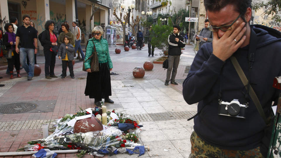 �STEDET:  En ung mann gr�ter p� �stedet i Athen der Alexandros Grigoropoulos (15) ble skutt av politiet l�rdag. Drapet ble starten p� oppt�yene i Hellas.  Foto:  REUTERS/Yiorgos Karahalis