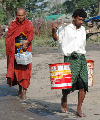 KOMBINASJONEN AV SYKLONEN NARGIS HERJINGER OG EN FALLITT �KONOMI HAR F�TT KATASTROFALE KONSEKVENSER FOR DEN HUMANIT�RE SITUASJONEN I BURMA: Dette bildet, som ble tatt p� l�rdag, viser en ung gutt som b�rer vann for munken i Dalla. Foto: AP/SCANPIX