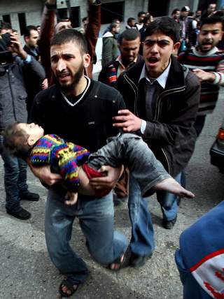 KJEMPER FOR SINE BARN: En palestinsk mann b�rer sitt skadde barn  EPA/MOHAMMED SABER/SCANPIX