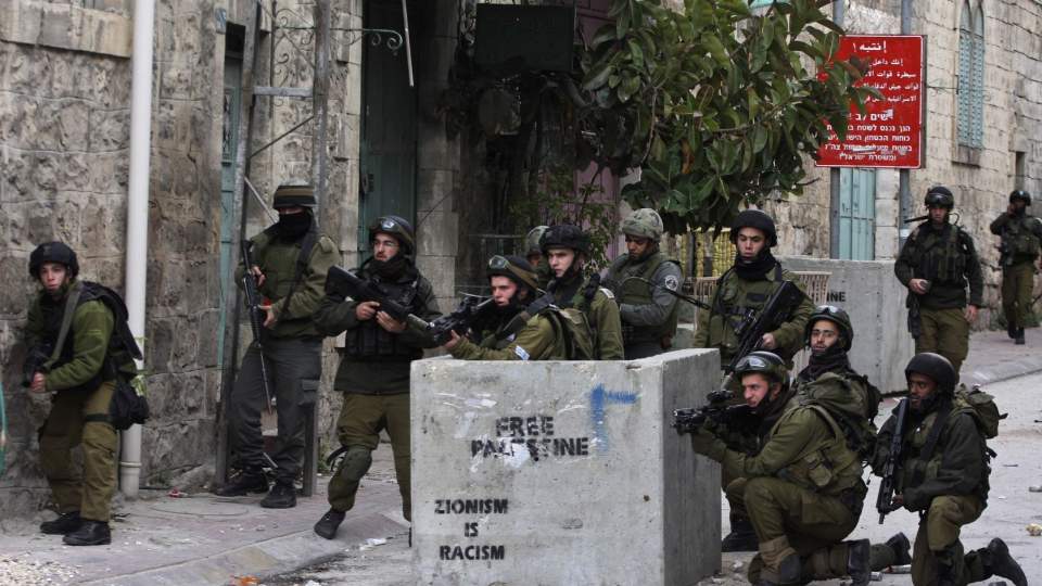 TROPPER GJ�RES KLARE: Her g�r israelske soldater i stilling under sammenst�t med palestinske demonstranter i Hebron i dag. Foto: AP