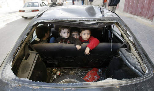 GAZA BY:  Noen barn sitter i baksetet i en bil som er �delagt i det israelske bomberegnet. Selv om omr�det er tett befolket har det v�rt f� sivile tap. Foto: AFP PHOTO/MAHMUD HAMS
