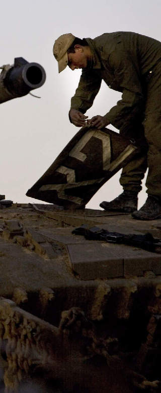 MOBILISERER: En israelsk soldat klargj�r en stridsvogn. Israel mobiliserer p� grensen mot Gaza. Foto: Ariel Schalit/AP/Scanpix