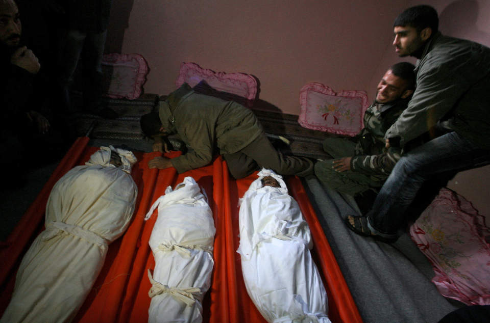 BARN: En palestinsk familie s�rger over tapet av sine tre sm� gutter. Guttene mistet livet da israelske fly bombet byen Rafah, s�r i Gaza i g�r kveld. Guttene er blant de 375 som har mistet livet i kampene. Foto: AFP PHOTO/SAID KHATIB/SCANPIX