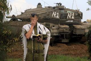 MORGENB�NN: En israelsk soldat ber sin morgenb�nn p� grensen mot Gaza. Israel mobiliserer p� grensen. Foto: Olivier Fitoussi/AFP/Scanpix