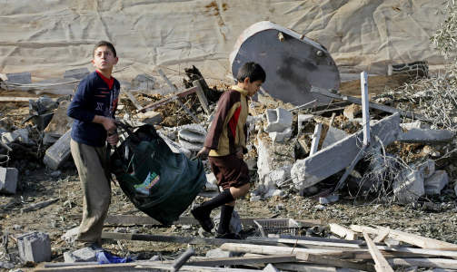 RAMMET: To palestinske gutter b�rer p� noen av eiendelene sine etter at huset de bodde i er blitt bombet. Foto: AFP/SAID KHATIB/Scanpix