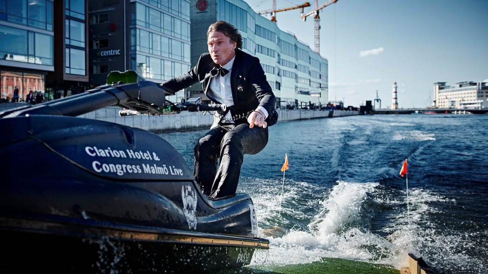 Petter Stordalen som kör vattenskoter i finkläder
