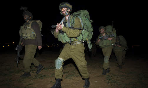 GIKK INN: Israelske soldater g�r i formasjon ut fra Israel og inn nord p� Gazastripen i dag. Foto: AP/SCANPIX