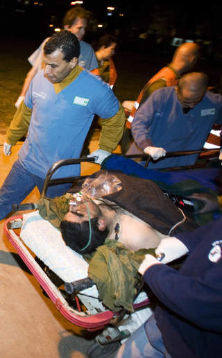 SKADD SOLDAT: En av soldatene i den israelske angrepsstyrken fraktes skadd til sykehus i g�r. Foto: ARIEL SCHALIT/AP/SCANPIX