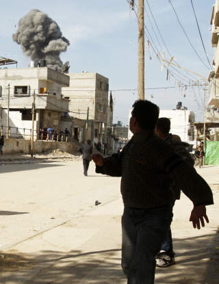 UNDER BESKYTNING: Palestinere l�per i dekning under et israelsk angrep mot Rafah s�r p� Gazastripen i g�r. Foto: IBRAHEEM ABU MUSTAFA/REUTERS/SCANPIX