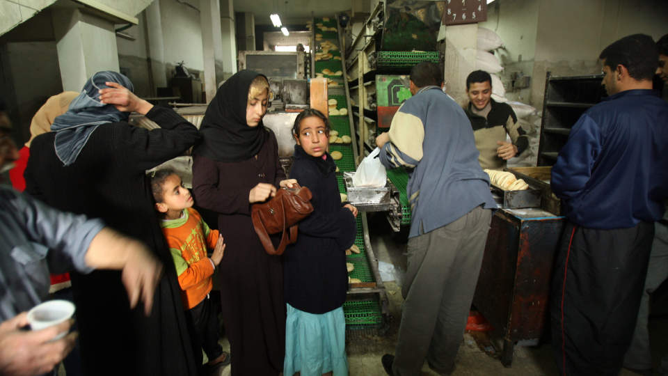 ENDELIG FIKK DE MAT: Palestinerne benyttet seg av de tre timene med fred som Israel ga dem i dag mellom klokka 13 og 16. K�ene hopet seg opp utenfor bakerier og matbutikker som �pnet for f�rste gang siden l�rdag. Foto: Mohammed Abed/Scanpix