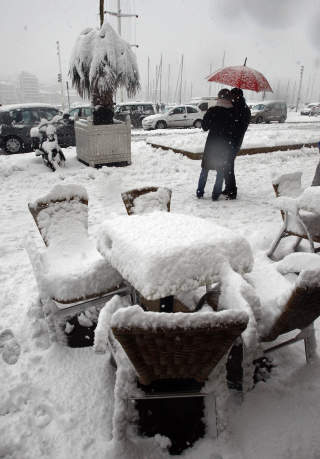 FORTAUSKAFE: Mennesker passerer en sn�dekket kafe i Gamlebyen i Marseille. Foto: SCANPIX/REUTERS/Jean-Paul Pelissier