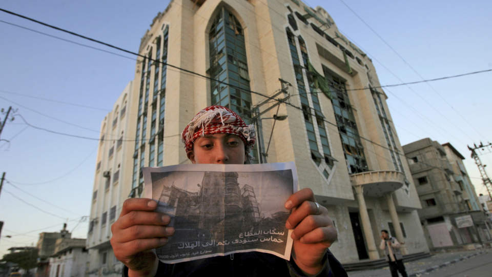 KOM DERE VEKK: En palestiner leser et flygeblad Israelerne har spredt ved grensa til Egypt. P� baksiden st�r det: Hamas vil f�re dere til �deleggelsen. Foto AP/Eyad Baba/Scanpix