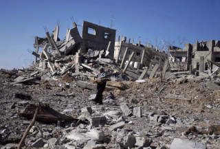 ISRAELSK LUFTANGREP: �n person ble drept da Israel bombet ulike m�l p� Gazastripa natt til fredag. Her samler en kvinne ved fra ruinene av en bygning som ble bombet i flyktningleiren Rafah. Foto: AP Photo/Khaled Omar/Scanpix