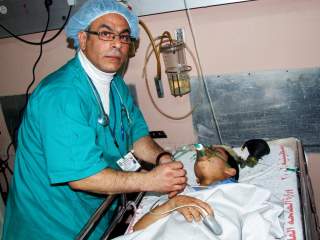 HEKTISK: Den norsk-palestinske anestesioverlegen Mohammad Abou-Arab behandler en ung gutt.  Foto: Hamada Hamada/Dagbladet