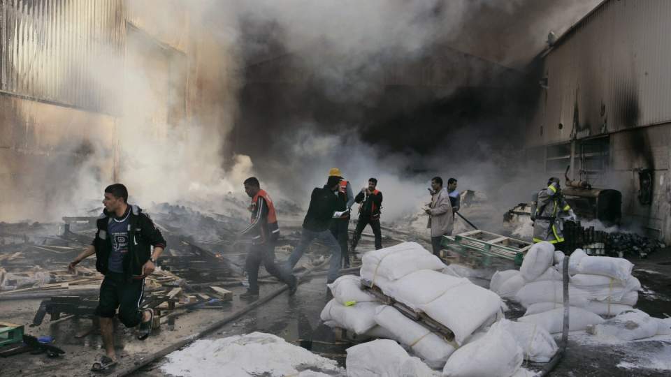 REDDER RESTENE: Brannfolk og FNs personell fors�ker � redde restene etter at dette matlageret tok fyr i dag. Foto: AP/Hatem Moussa/SCANPIX