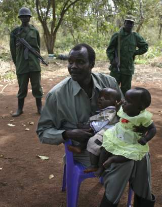 MANNEN BAK DET HELE: Joseph Kony mener han er Guds sendebud her p� jorden. Krigen han var med p� � starte i Uganda, er en av Afrikas lengste og blodigste konflikter. Her er han fotografert sammen med barna Lacot og Opiyo. Foto: Scanpix