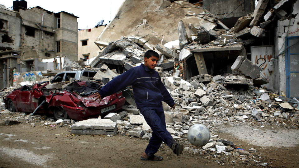 IKKE MYE IGJEN: En palestinsk gutt spiller fotball foran raserte hus og biler i Jabalya nord p� Gaza-stripen. Foto: Jerry Lampen/Scanpix