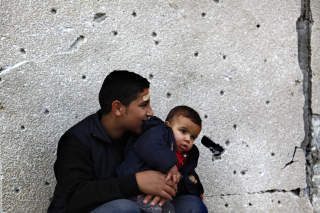 I RUINER: En gutt holder lillebroren i utkanten av Jabalya p� Gaza. REUTERS/Jerry Lampen (GAZA)
