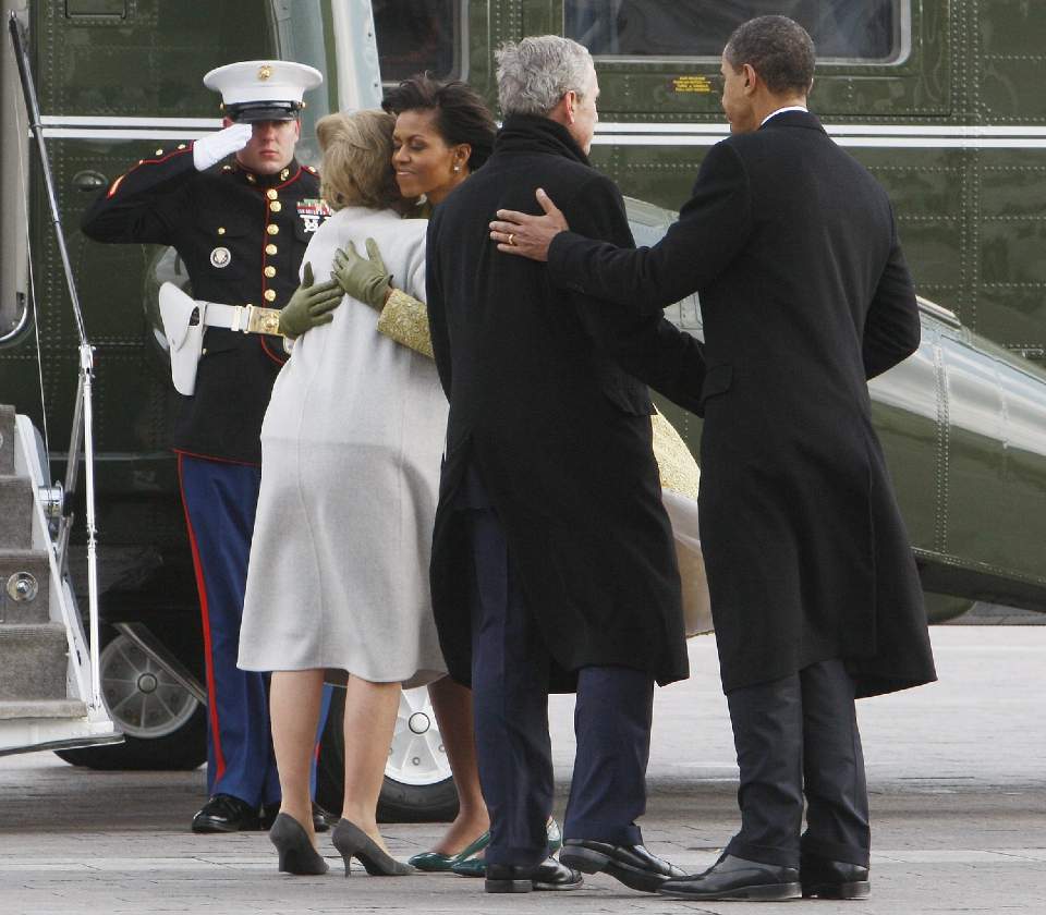 GOD TUR: President Barack Obama og kona Michelle fulgte tidligere president George W. Bush og hans kone Laura ned trappen p� Capitol Hill og til deres helikopter. Det to parene delte klemmer og lykke�nskninger f�r helikopteret tok av fra Washington. Foto: CHARLES DHARPAK/AP/SCANPIX