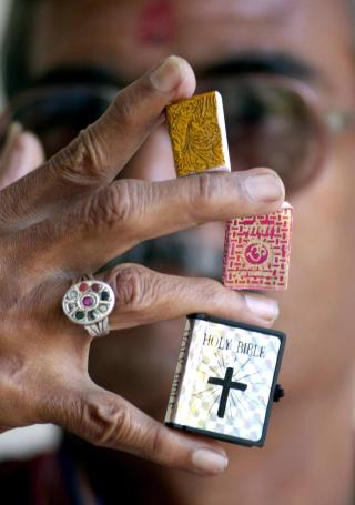 RELIGIONENE OPPTRER MED HELBREDERE: Jesus og andre hellige personer har blitt beskrevet som helbredere. Her ser vi bittesm� utgaver av Koranen (�verst), hinduenes Bhagvad Gita og Bibelen. Foto: EPA/AFPI/INDRANIL MUKHERJEE
