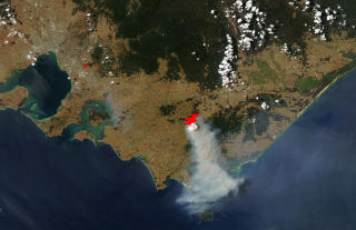 MULIG � SE FRA SATELITT: Skogbrannen i Australia er godt synlige p� dette satelittbilde. Den norske klimaforskeren Erik Kolstad tror at den ekstreme heten skyldes flere faktorer: klimaendringer, en regional langvarig fase med h�yere temperaturer og et lokalt fenomen, for eksempel h�yere havtemperaturer. Foto: AFP PHOTO/NASA EARTH OBSERVATORY MODIS/SCANPIX