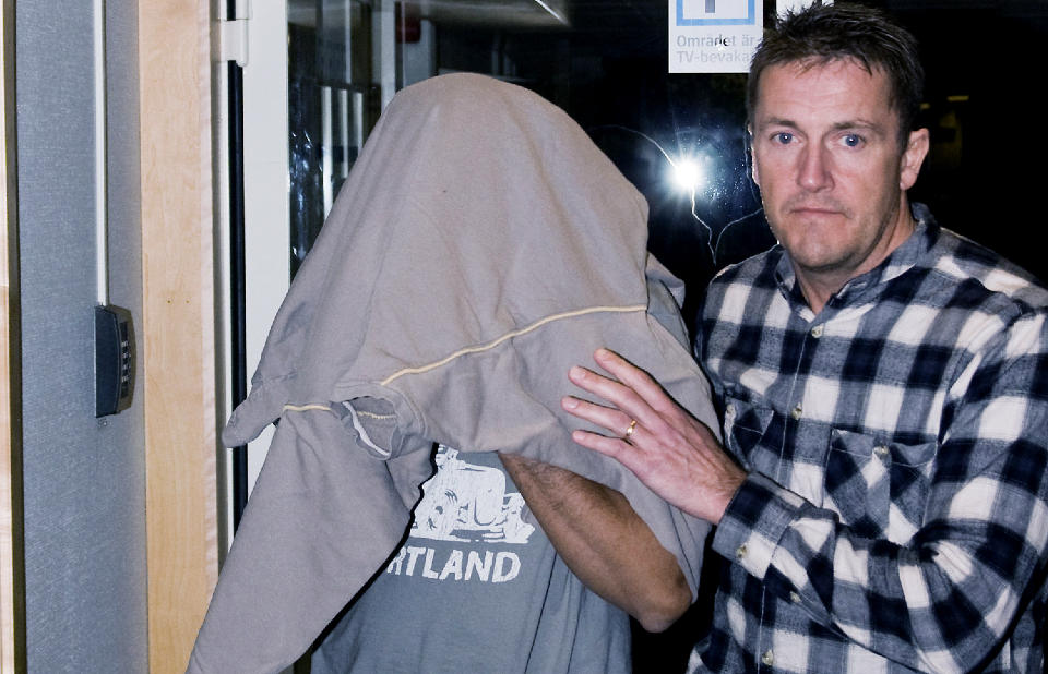 FENGSLET: Politiet mistenker mannen som her blir geleidet til cella av en politimann for � ha planlagt et sv�rt spesielt drap p� ekskj�resten. Foto: FREDRIK SUNDVALL / SIKISFOTO