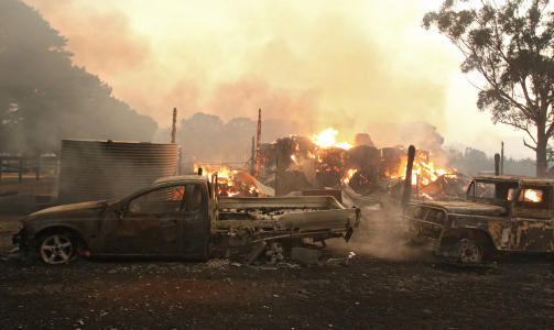 TATT AV FLAMMENE: Hus og biler er i full fyr i Australia. Foto: AFP