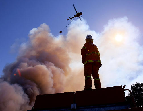 MASSIV INNSATS: De rekordstore brannmannskapene p� bakken, st�ttet av helikoptre og utallige frivillige, har enn� ikke klart � slukke de verste brannene.