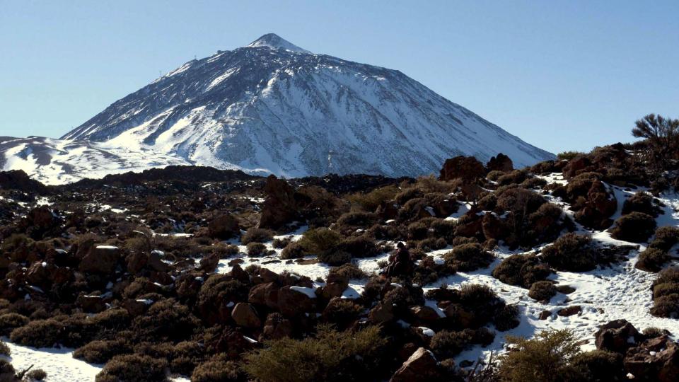 SJELDENT SYN: Sn� dekker vulkanen Teide og den omliggende nasjonalparken. Politiet har sperret veiene inn til de sn�dekte omr�dene for � hindre ulykker. Foto: Scanpix/EPA/Manuel L�rida
