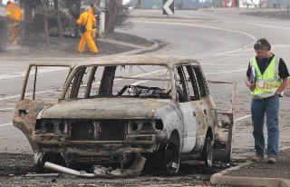 UTBRENTE VRAK: En rekke mennesker er blitt slukt av flammene mens de fors�kte � flykte i biler. Foto: SCANPIX/AFP PHOTO/William WEST