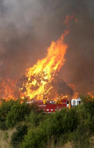 TIL V�RS: Brannmannskaper kjemper mot flammene ved Tonimbuk. Store deler av en nasjonalpark i omr�det st�r i brann. Foto: SCANPIX/EPA
