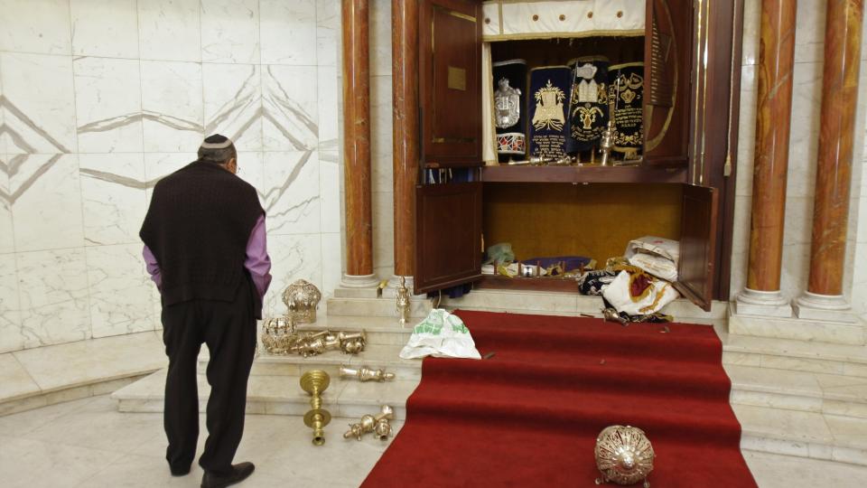 VANDALISERT:  Et medlem av det j�diske samfunnet ser p� det vandalisterte alteret i en synagoge i Caracas i Venezuela. N� er 11 personer p�grepet for angrepet. Foto: AP Photo/Carlos Hernandez